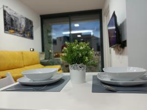 une table avec deux plaques blanches et une plante sur elle dans l'établissement Centro Torremolinos Apto 1 hab 1-4 personas WiFi Terraza, à Torremolinos