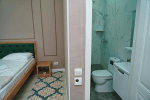 y baño con cama, aseo y lavamanos. en Halal Apart Hotel Almaty, en Almaty
