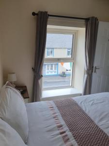 a bedroom with a bed and a window at Willards B&B in Bundoran