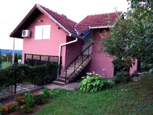 a pink house with stairs on the side of it at Apartman 1 - Banoštor in Banoštor