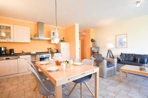 una cucina e un soggiorno con tavolo in legno di Ferienwohnung Am Leuchtfeuer EG a Wustrow Altre 10 foto