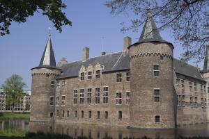 a large brick building with two towers on top at Golden Tulip West Ende in Helmond