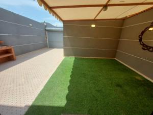 a room with a green floor in a garage at شاليهات سويت هوم الدرب الكدره in Ad Darb