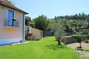 a yard of a house with a green lawn at Casa de Campo - Cinfães do Douro in Cinfães