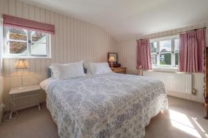 ein Schlafzimmer mit einem großen Bett und zwei Fenstern in der Unterkunft Gothic House Cottage in Clare + 30 Fotos