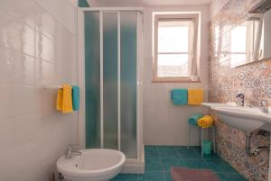 a bathroom with a shower and a toilet and a sink at B&B Tor Di Lupo in Mattinata