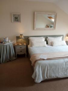 a bedroom with two beds and a table with a mirror at Clifden Bay Lodge in Clifden