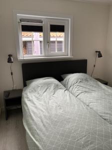 a white bed in a bedroom with a window at 2 persoons zon en zee in Westkapelle