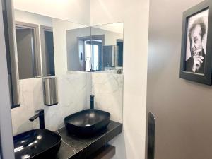 a bathroom with a black sink and a mirror at Urban Habitat Capsule Beds in Nicosia