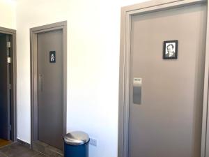a hallway with two doors and a trash can at Urban Habitat Capsule Beds in Nicosia