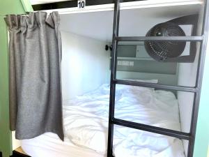 a bunk bed with a ladder and a fan at Urban Habitat Capsule Beds in Nicosia