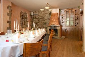 a dining room with a long table and a fireplace at Berggasthof Butterberg in Bischofswerda