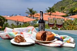 a table with a cake and two glasses of wine at Teixeira House in Arco da Calheta