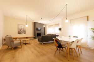 a dining room and living room with a table and chairs at Entre Conventos in Toledo