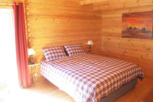 - une chambre avec un lit dans une cabane en rondins dans l'établissement la liberté des hirondelles, à Saint-Laurent-de-la-Barrière