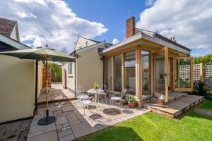 a conservatory with a table and chairs in a yard at Gothic House Cottage in Clare