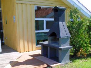 a stone oven sitting outside of a house at 12 person holiday home in Otterndorf in Otterndorf