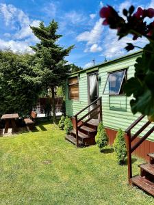 a green trailer with a bench and a picnic table at Riviera Zator in Zator