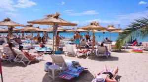 a beach with people sitting in chairs and umbrellas at Апартаменти Свети Георги - Saint George Apartments in Kavarna