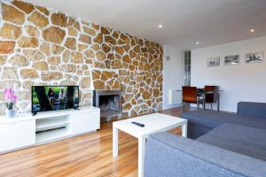 sala de estar con pared de piedra en LifeWay CRANC Xperience by GuestWay, en Salou