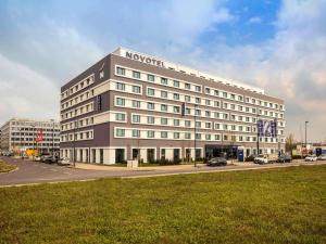 デュッセルドルフにあるNovotel Duesseldorf Airportの車の通り沿いの大きな白い建物