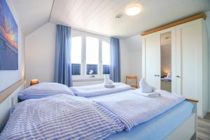 two beds in a bedroom with a window at Ferienhaus Daheim in Borkum
