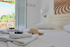 a group of towels and a hat on a bed at Aegeo Inn in Antiparos