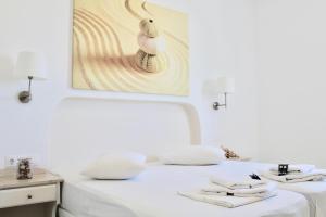 a white bed with white sheets and towels on it at Aegeo Inn in Antiparos