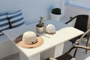 two hats sitting on a table with chairs at Aegeo Inn in Antiparos