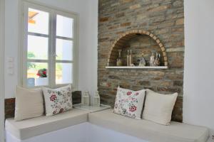 a living room with pillows and a brick wall at Aegeo Inn in Antiparos