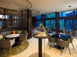 a restaurant with tables and chairs and windows at Ibis Styles Ambassador Seoul Gangnam in Seoul