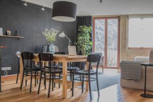 comedor con mesa de madera y sillas negras en Spot Apartments Sao Bento, en Oporto