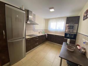 a kitchen with a stainless steel refrigerator and a table at La Tahona 27-H in Zahara de los Atunes