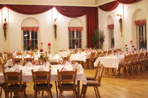 un salón de banquetes con mesas y sillas blancas en Hotel Gasthof zur Post, en Wolfegg