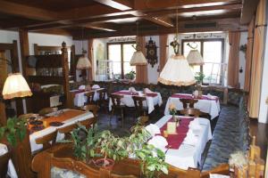 a restaurant with tables and chairs in a room at Hotel Gasthof zur Post in Wolfegg