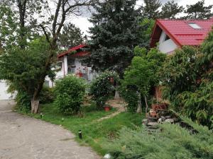 uma casa branca com telhado vermelho e árvores em Aeroport - Relax Casa Victoria em Otopeni