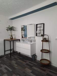 baño con lavabo, escritorio y estante en L'appartement du Pilori 1er étage, en Saint-Jean-dʼAngély