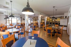 jadalnia ze stołami i krzesłami w restauracji w obiekcie Hotel Admiral w mieście Lipno nad Vltavou