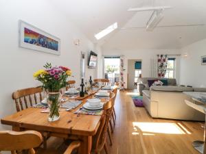 a dining room and living room with a table and chairs at Old Anvil Cottage in Newton Abbot