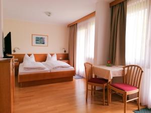 um quarto de hotel com uma cama e uma mesa em Strandpension Liane em Sankt Kanzian