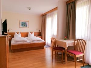 a hotel room with a bed and a table at Strandpension Liane in Sankt Kanzian