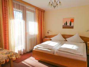 um quarto com uma cama e uma grande janela em Strandpension Liane em Sankt Kanzian