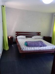 1 cama con sábanas y almohadas moradas en una habitación en Appartement Beau Séjour, en Dakar