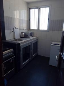 una pequeña cocina con fregadero y microondas en Appartement Beau Séjour, en Dakar