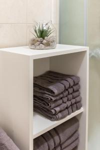 a white shelf with towels on it in a bathroom at Peaceful Rogla Apartment in Zreče