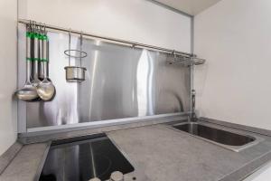 a stainless steel kitchen with a sink and utensils at Easylife - Amazing apartment at Rialto Venezia in Venice