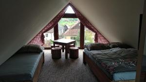Schlafzimmer mit einem Bett, einem Tisch und einem Fenster in der Unterkunft Privat LeNa in Ružomberok
