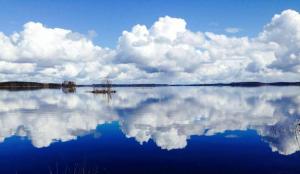 un gran cuerpo de agua con una nube en Paksuniemen Majatalo, en Rääkkylä