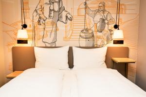 a bedroom with a bed with a painting on the wall at McDreams Hotel München-Nord in Eching