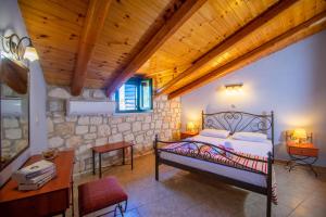 a bedroom with a bed and a wooden ceiling at Ammos Zante Villas in Vasilikos